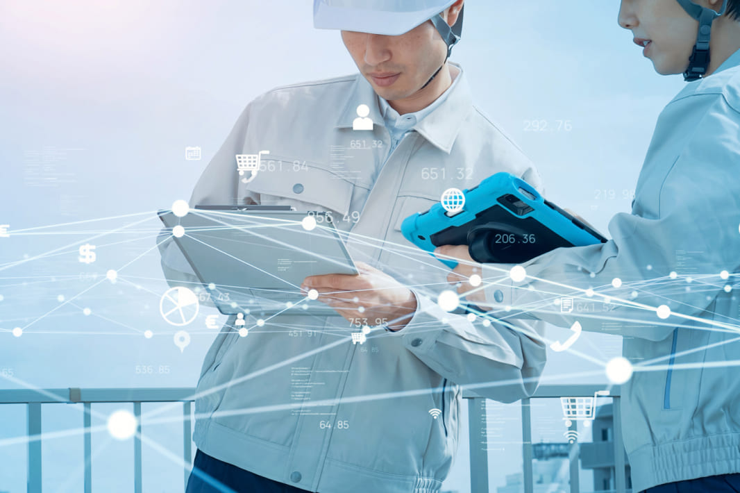 倉庫内で荷物とタブレットを確認する作業員