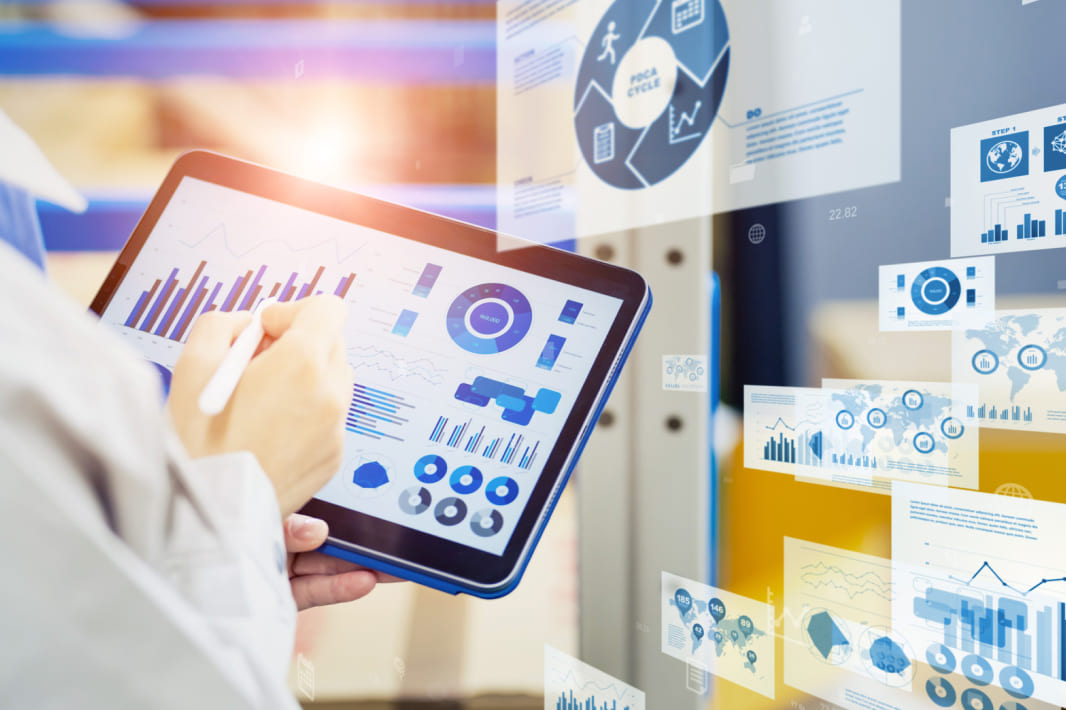 倉庫内で荷物とタブレットを確認する作業員