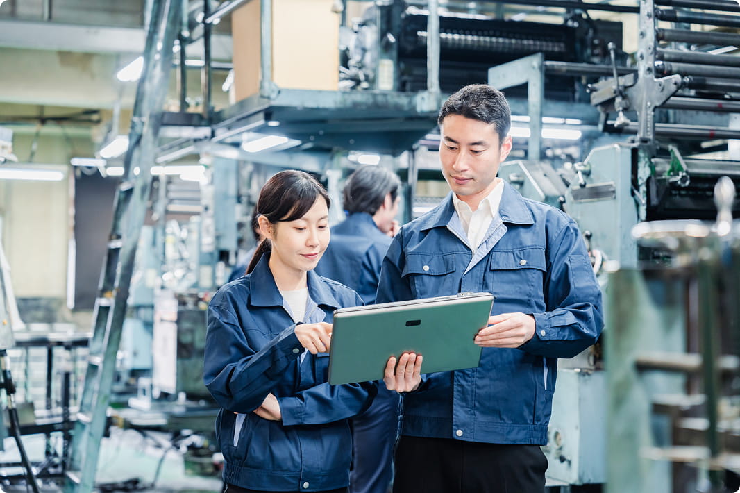 工場内でタブレットを確認する作業員